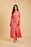 Woman wearing a coral pink dress on a white background