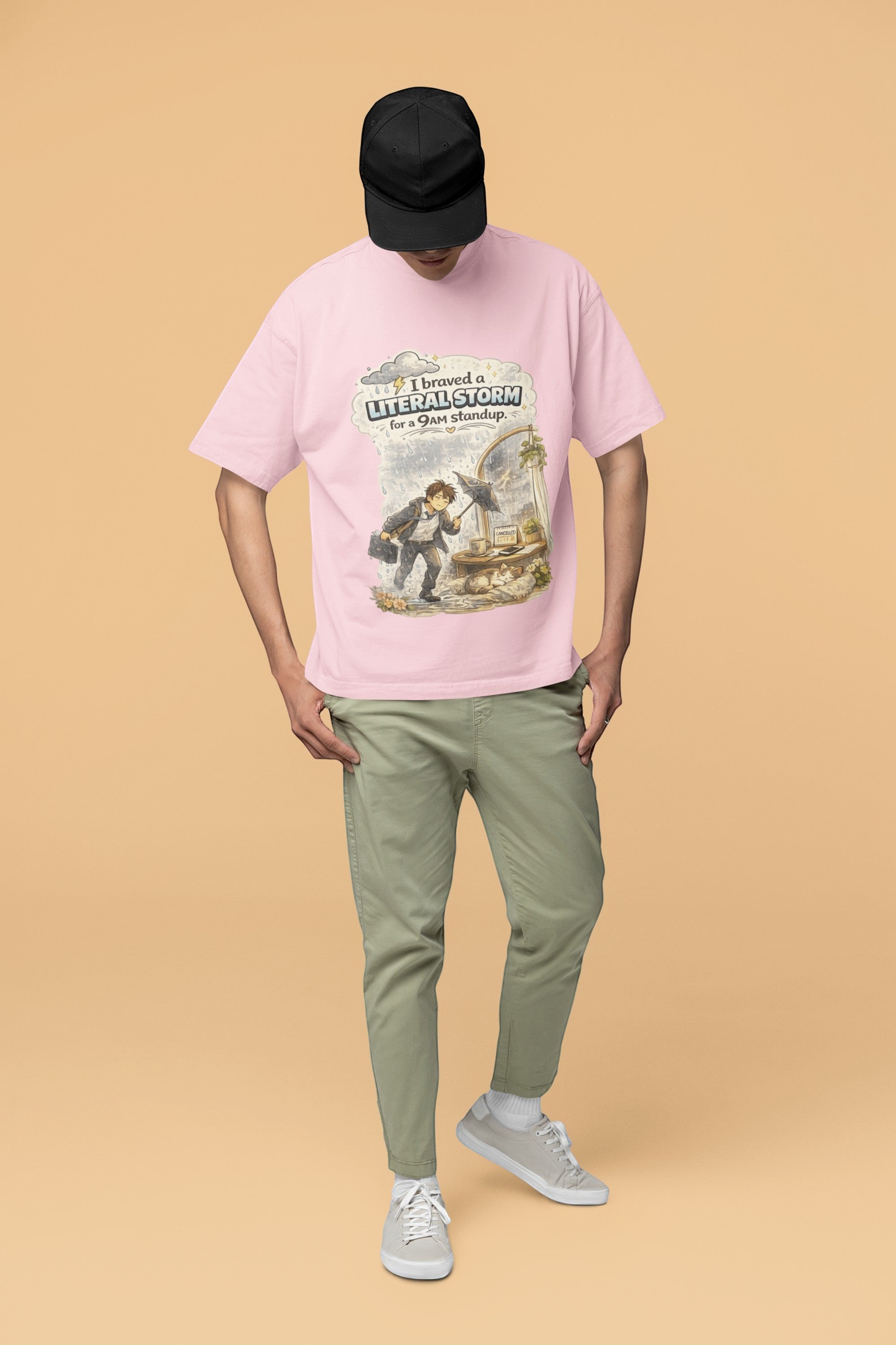 Snuggle Spot unisex oversized pink terry-knit t-shirt with a graphic print, worn by a model in a black cap.