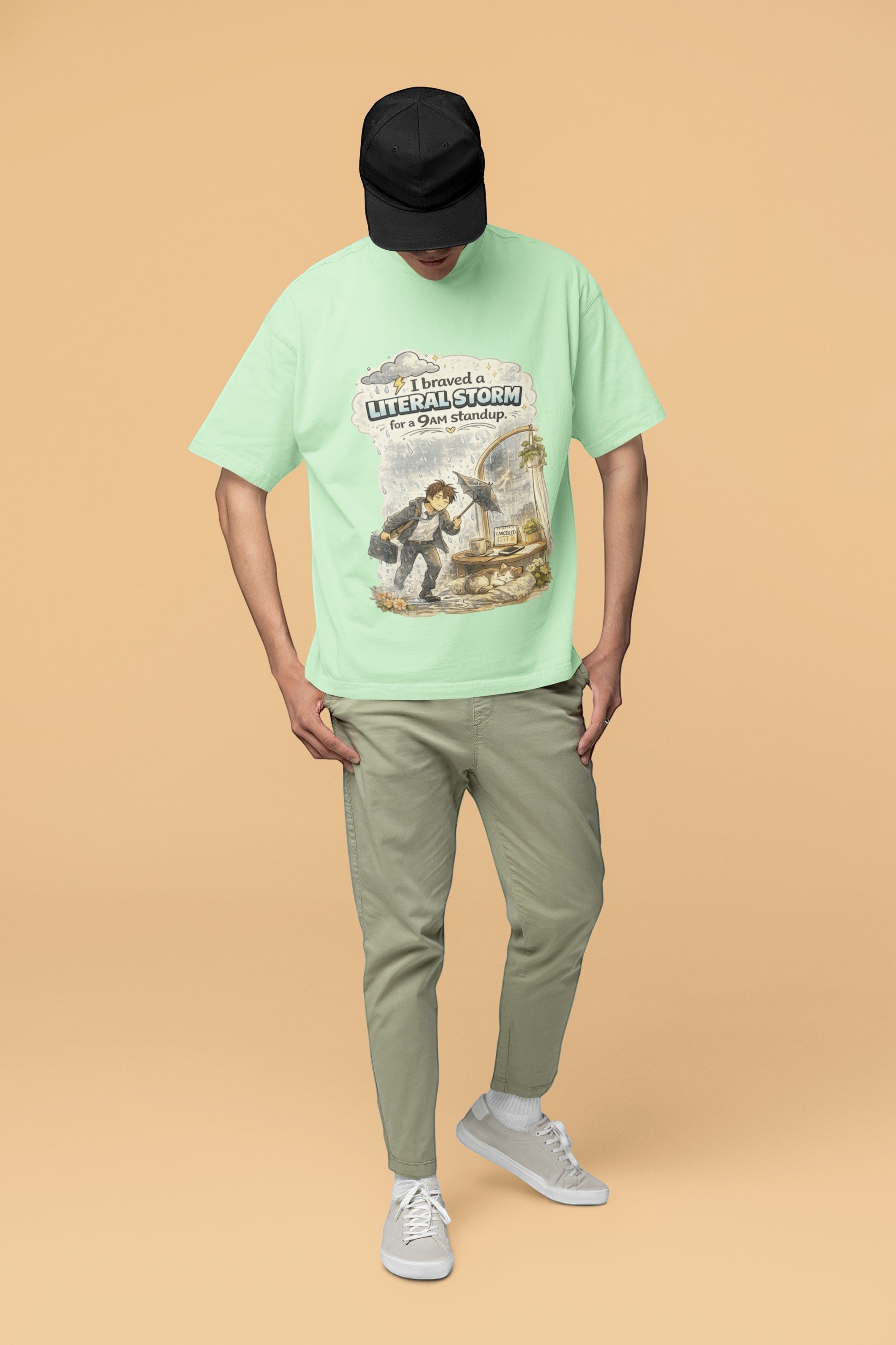 Snuggle Spot unisex oversized mint green terry-knit t-shirt with a graphic print, worn by a model in a black cap.