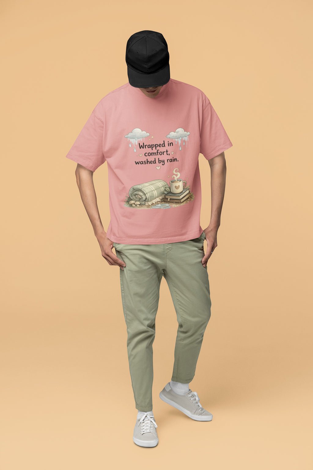 Snuggle Spot unisex oversized pink terry-knit t-shirt with graphic print, worn by a man in a black cap and olive pants.