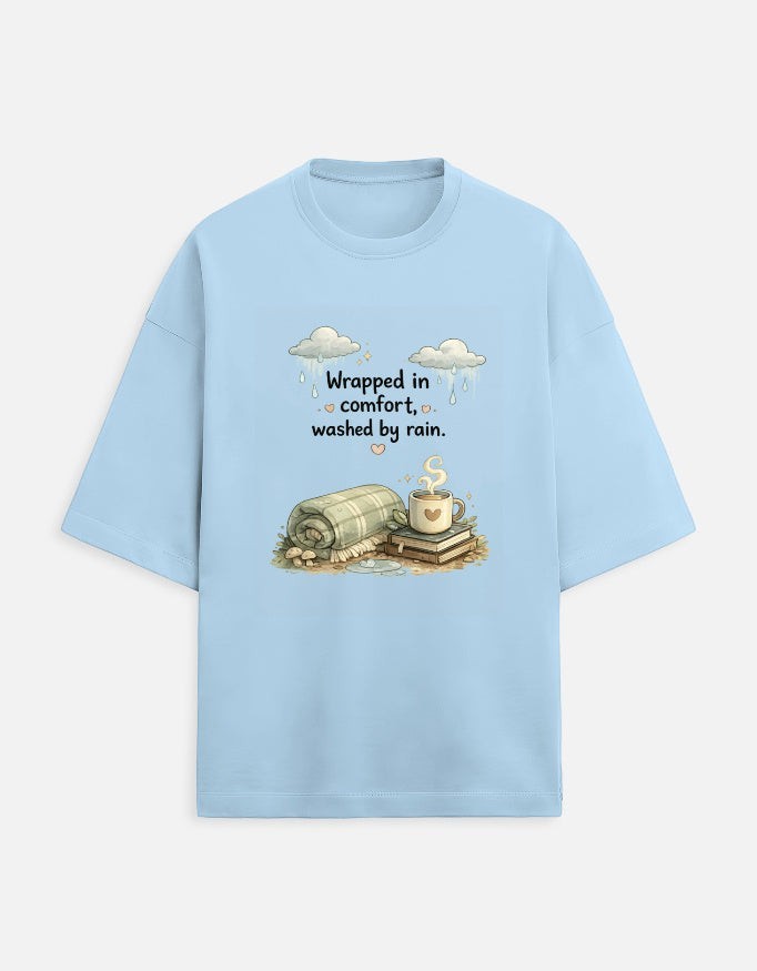 Snuggle Spot light blue oversized terry-knit t-shirt with a graphic print of a blanket, books, and coffee mug.