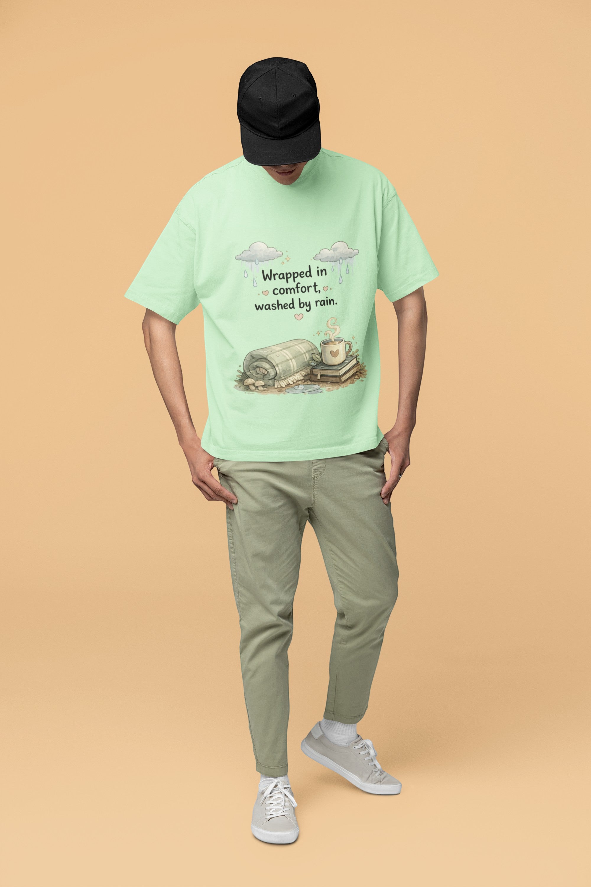 Snuggle Spot unisex oversized light green terry-knit t-shirt with a cozy rain-themed graphic print on a model.