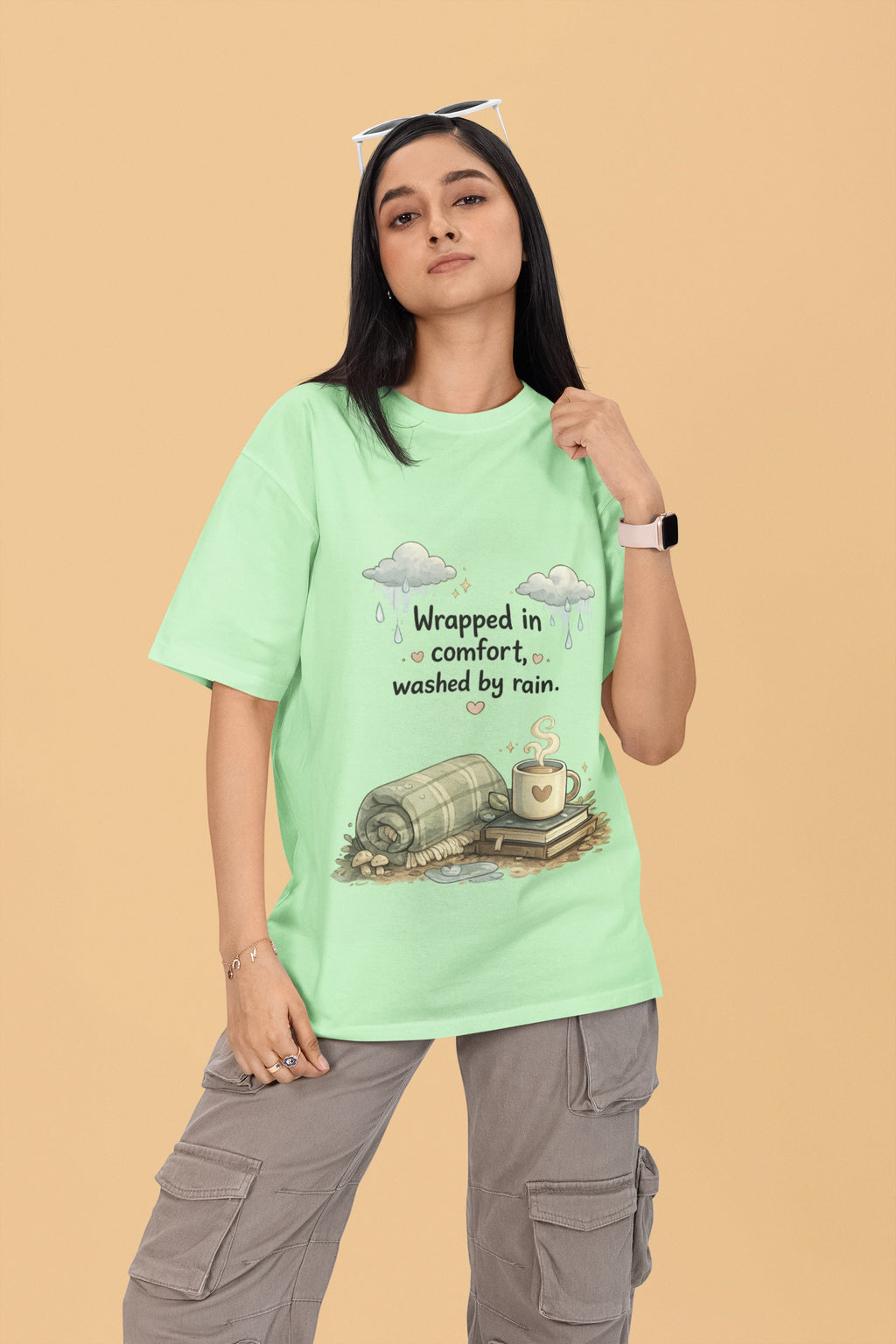 Model wearing a light green Snuggle Spot oversized terry-knit t-shirt with a cozy rain and coffee graphic print.