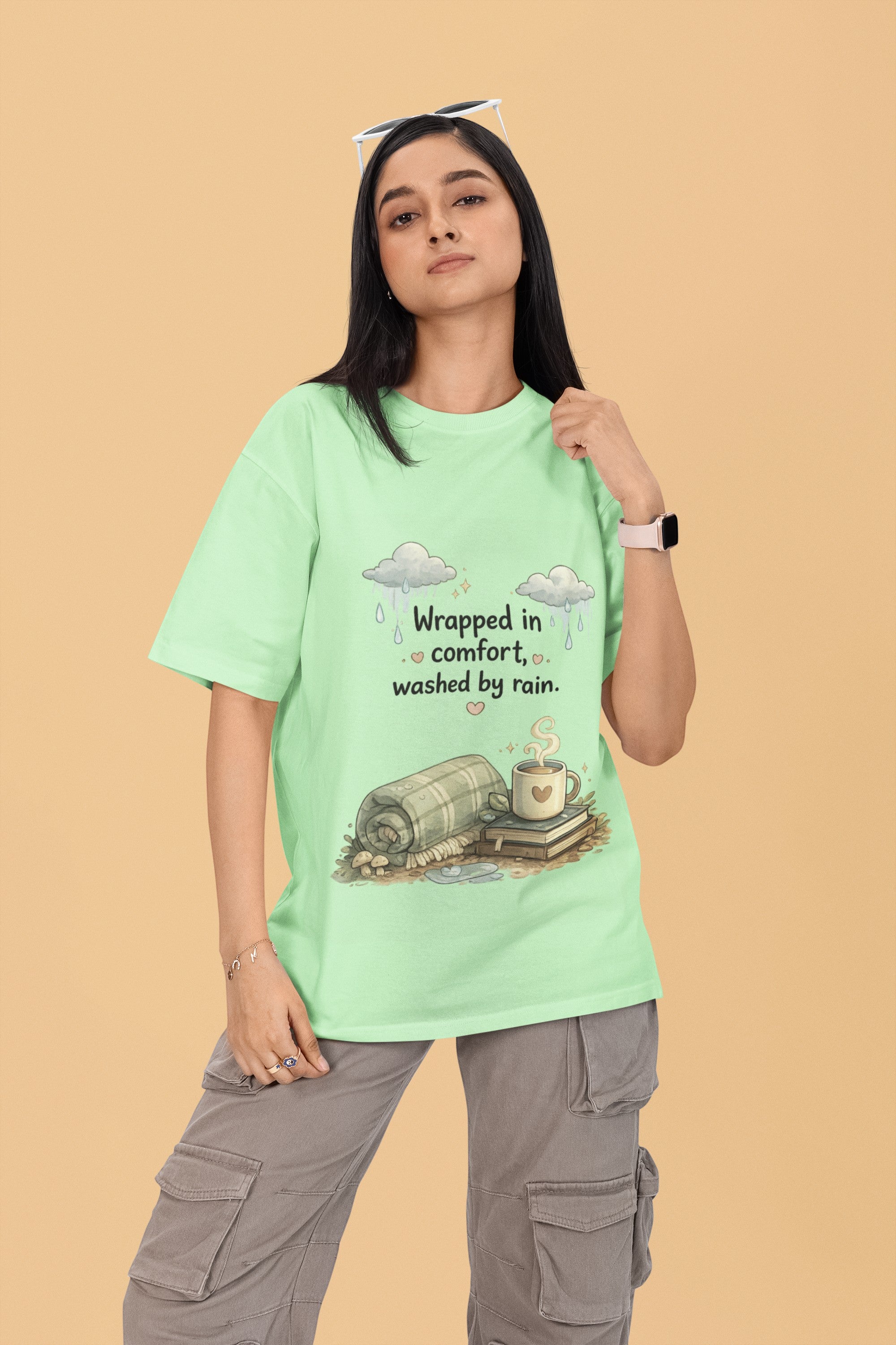 Model wearing a light green Snuggle Spot oversized terry-knit t-shirt with a cozy rain and coffee graphic print.