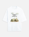 Snuggle Spot white oversized terry-knit t-shirt with Wrapped in Comfort graphic featuring a cozy mug and blanket.
