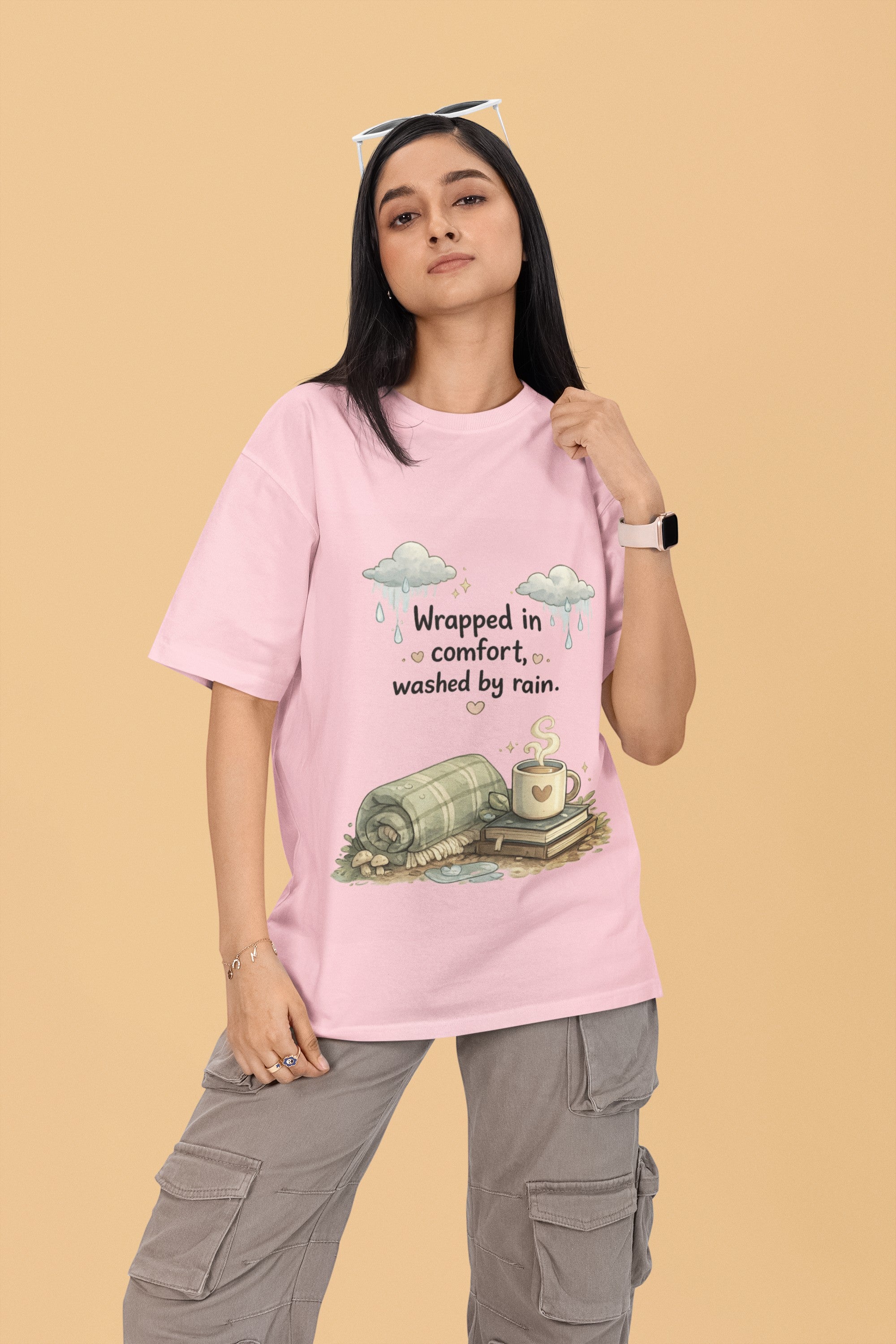 Model wearing a Snuggle Spot light pink oversized terry-knit t-shirt with a cozy rain and coffee graphic print.