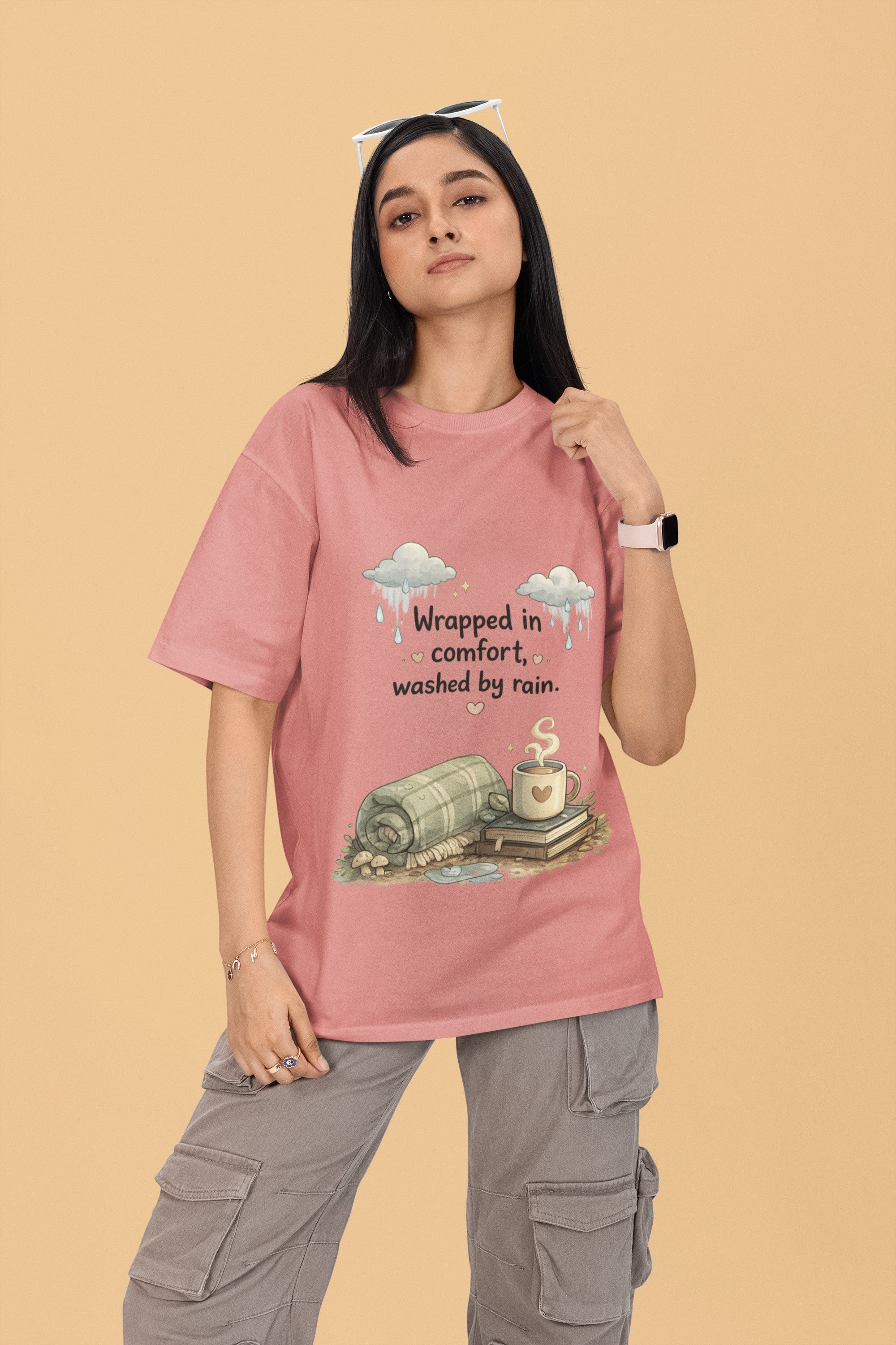 Snuggle Spot oversized pink terry-knit t-shirt with a cozy graphic print on a model wearing grey cargo pants.