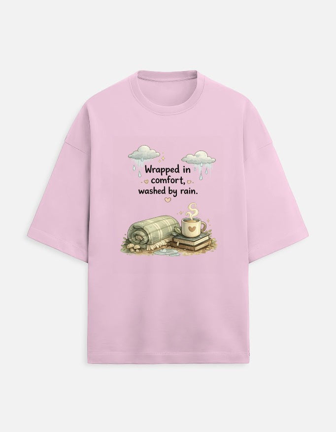 Snuggle Spot light pink oversized terry-knit t-shirt with a cozy graphic print of a blanket, coffee, and rain clouds.