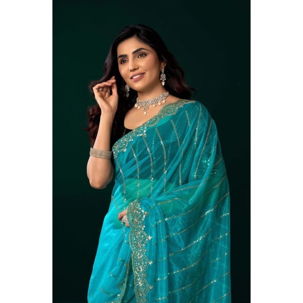 Snuggle Spot turquoise net sequence saree with unstitched blouse, featuring intricate sequin embellishments and a decorative border.