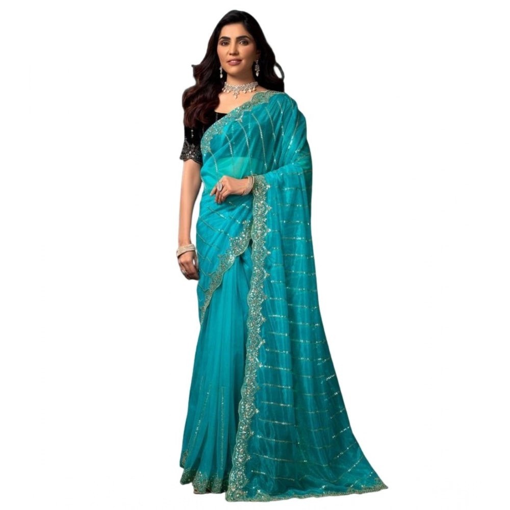 Snuggle Spot turquoise net saree with sequence work and embellished border, paired with a black blouse.